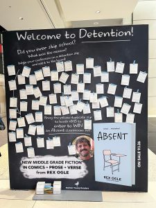 A display board titled "Welcome to Detention!" with confession slips about skipping school, promoting Rex Ogle's book "Absent" and advertising a contest to win an Absent classroom set.